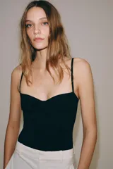Body lencero color bordó de poliamida, con escote corazón con aro, tirantes finos regulables y cierre inferior a presión.