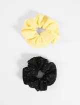 Set de dos gomitas para el pelo tipo scrunchie, una amarilla y otra negra, ambas con pequeños strass plateados.
