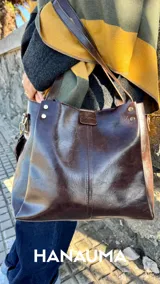 Cartera tipo shopper confeccionada en cuero sintético premium de color marrón oscuro, con doble asa de hombro y diseño estructurado con costuras verticales decorativas.
