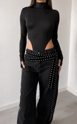 Cinto de terciopelo negro con tachas metálicas plateadas distribuidas a lo largo de toda la pieza.