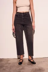 Pantalón de jean negro con efecto gastado y pequeños brillos. Corte recto, tiro alto y terminación desflecada.