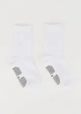 Par de medias blancas de media caña con antideslizante en la planta del pie.