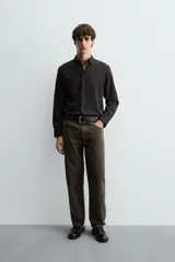 Camisa de corte slim fit, color negro, con cuello italiano, manga larga con puños abotonados y cierre frontal de botones. Confeccionada en tejido de fácil cuidado que minimiza la necesidad de planchado.