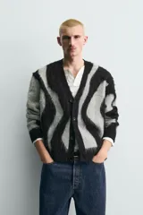 Cárdigan de punto con acabado cepillado, diseño de jacquard con patrón abstracto de ondas en gris y negro, cuello en pico, manga larga y cierre frontal con botones.