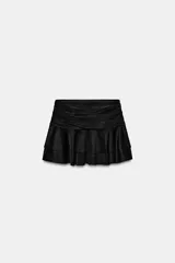 Falda corta de tiro bajo con diseño de volantes en capas y acabado efecto gamuza. Cuenta con cierre lateral mediante cremallera oculta.