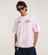 Remera oversized de algodón con teñido tie-dye en blanco y rosa. Presenta un cuello redondo y un estampado frontal con la palabra "Chaos" y un diseño de llamas en color rosado.