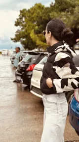 Campera puffer cropped color verde militar con mangas y capucha de polar estampado con cebra en blanco y negro.