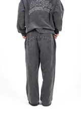 Pantalón de jogging unisex color negro lavado, confeccionado en frisa gamuzada, con cordón de ajuste en la cintura y bordado en la espalda.