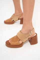 Sandalia de cuero color camel con punta redonda, plataforma de 2 cm y taco cuadrado forrado en cuero de 7 cm. Tiene tira ancha sobre el empeine y pulsera con hebilla.