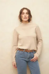 Polera color beige de tejido de punto con cuello alto y mangas largas.