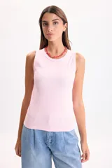 Musculosa de rib color rosado, de corte al cuerpo y escote redondo.
