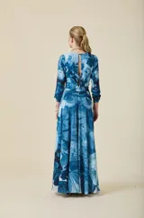 Vestido largo de crepé liviano con estampado floral en tonos azules. Presenta escote en V, mangas largas y falda amplia con movimiento. Incluye un lazo en la cintura que permite un ajuste entallado.