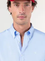 Camisa celeste lisa de hombre, marca El Ganso, confeccionada en tejido 100% algodón pin point. Corte regular fit, cuello clásico, cierre con botones y logo bordado en el pecho.