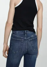 Jeans de corte skinny y tiro alto, confeccionados en tejido denim de algodón con elastano. Presentan diseño clásico de cinco bolsillos, cierre de cremallera con botón y trabillas en la cintura.