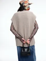 Chaleco de tejido de punto con lana y alpaca, de corte relajado y caída recta. Presenta laterales abiertos con cierre de botones y cuello redondo.