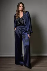 Pantalón sastrero azul marino con estampado de flores negras.