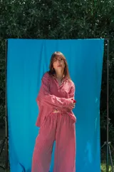 Pantalón de fibrana con diseño de rayas verticales en tonos rojos y blancos, de corte amplio y fluido.