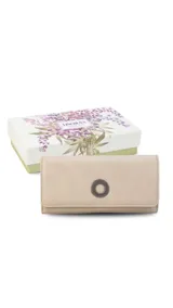 Billetera larga de símil cuero color marrón claro, con solapa frontal decorada con un aro metálico central. Cuenta con múltiples compartimentos internos para tarjetas, billetes y un monedero con cierre.