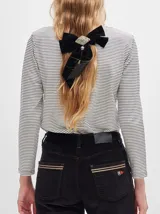 Remera de manga larga con cuello redondo y estampado a rayas horizontales en tonos marrón y negro. Tiene un logo bordado en el pecho de color rojo.