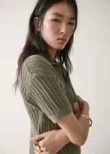 Chaleco de punto verde militar con diseño texturizado, cuello camisero, manga corta y cierre parcial de botones en la parte delantera.