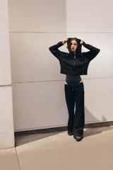 Pantalón flare de tiro medio, color azul, confeccionado en tejido de punto elástico. Cuenta con cintura elástica ajustable con cordón, bolsillos delanteros y corte amplio en las piernas.
