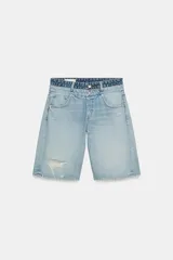 Bermudas de denim de tiro medio y calce regular, con diseño de cinco bolsillos. Presenta detalle de doble cintura con doble botonadura y rotos en la parte delantera. Cierre frontal con cremallera y botones metálicos.