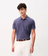 Remera polo masculina de tejido piqué color azul, con cuello clásico abotonado, manga corta y bolsillo aplicado en el pecho. Presenta detalles de líneas contrastantes en el cuello y los puños.