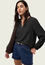 Blusa de viscosa color marrón, con escote en V profundo, mangas tres cuartos abullonadas y puños elásticos.