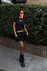 Camiseta corta negra con cuello redondo y estampado blanco con el logo de la marca "ARTE Independent Design".