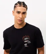 Remera negra de manga corta con cuello redondo y corte comfort, confeccionada en algodón. Presenta diversos estampados gráficos y lettering en estilo graffiti en la espalda.