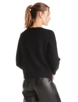 Cardigan de punto con textura tipo waffle, color blanco, con escote a la base, cierre frontal con botones metálicos dorados y detalles desflecados en la tapeta y los bolsillos simulados.