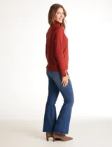 Polera de tejido fino, color rosado, con cuello alto, manga larga y detalle de tajo en los puños.