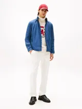 Campera acolchada de hombre, color azul marino, con cuello alto y cierre frontal de cremallera. Presenta bolsillos laterales con cierre y el logo de Tommy Hilfiger bordado en el pecho.