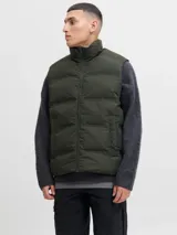 Chaleco acolchado de diseño puffer con cuello alto y cierre frontal con cremallera. Presenta un acabado liso y minimalista, ideal para capas de abrigo.