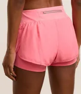 Short deportivo tipo runner 2 en 1, color celeste, con cintura elástica y bajo redondeado. Confeccionado en microfibra de poliéster con forro interno elástico.
