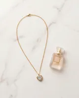 Collar de acero con baño de oro, compuesto por una cadena fina y un dije en forma de corazón con incrustación de circonia brillante.