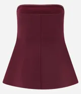 Blusa de crepé bordó sin breteles, con diseño entallado, recortes verticales y ruedo peplum con leve abertura.