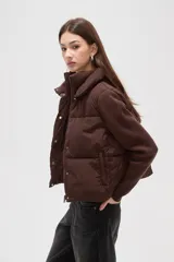 Campera híbrida con cuerpo delantero acolchado tipo puffer y mangas de tejido de punto acanalado con cuello alto. Presenta un diseño corto y holgado con cierre frontal oculto.