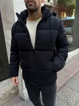 Campera puffer de gamuza negra con capucha desmontable forrada en corderito, cierre frontal y bolsillos laterales.