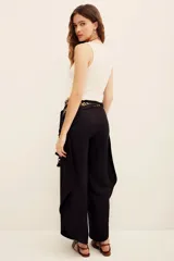 Pantalón negro de lino y viscosa, de tiro alto, corte holgado y diseño fluido con silueta ancha.