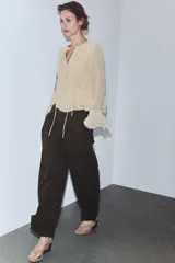 Pantalón cargo de tiro medio confeccionado en algodón, con diseño de pierna tipo balloon. Presenta bolsillos laterales de plastrón con solapa y botones a presión, trabillas en la cintura y detalle de trabilla con botón en el bajo.