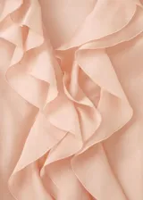 Blusa de lyocell color rosado pálido, de diseño recto con escote en V, detalle de volantes en la solapa y manga larga con puños ajustables.