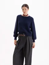 Sweater de tejido de punto con textura suave, cuello redondo y mangas largas con hombros caídos. Presenta un diseño de calce relajado con puños y ruedo acanalados.