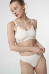 Sostén tipo bralette color beige, de tela acanalada, con breteles ajustables, doble tela y espalda con broche de tres medidas. Sin relleno ni aro.