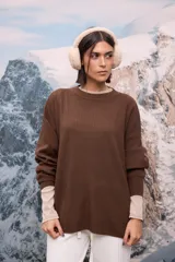 Buzo oversize de tejido de punto con textura acanalada, color blanco, de cuello redondo, manga larga y tajos laterales en el ruedo.