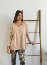 Sweater beige de tejido de punto, con escote en V, corte oversize y tajos laterales.