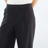 Pantalón de corte ancho y tiro medio, color negro, con detalle de cintura elástica visible estilo bóxer y bolsillos laterales.