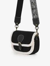 Bolso tipo bandolera confeccionado en eco suede color tostado con bordes de corderito sintético blanco. Presenta una solapa con cierre imantado y una hebilla decorativa frontal en cuero sintético marrón. Incluye una correa larga de jacquard estampado y un bolsillo interno.