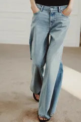 Jeans de tiro bajo y pierna muy ancha estilo wide leg, en tono celeste claro con efecto lavado. Cuenta con diseño de cinco bolsillos, trabillas para cinturón y cierre frontal con cremallera y botón metálico.