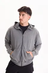 Campera de felpa sin friza con capucha y cierre frontal, corte oversize y efecto lavado stone wash en color gris. Cuenta con bolsillos tipo canguro en el frente.